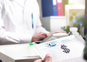 Medical and health care prices concept. Patient holding paper document, insurance, bill or invoice with dollar sign in doctor office in hospital or emergency room. High costs or expenses in healthcare
